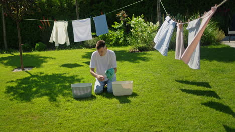 man doing laundry in backyard