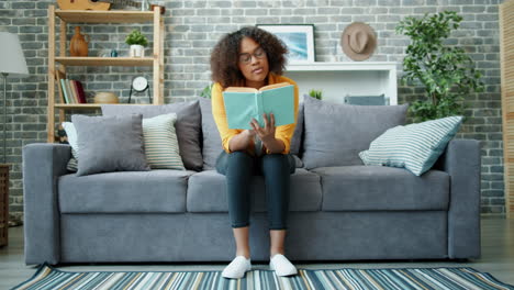 mujer leyendo un libro en un sofá