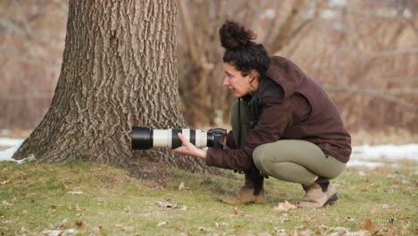 hermosa mujer joven fotógrafa de vida silvestre, profesional, en un parque de la ciudad