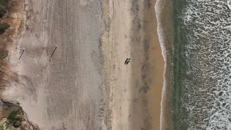 Birdseye-view-over-the-beautiful-sandy-beach-of-Carlsbad-California,-USA-with-waves-crashing-on-the-beach-at-sunset