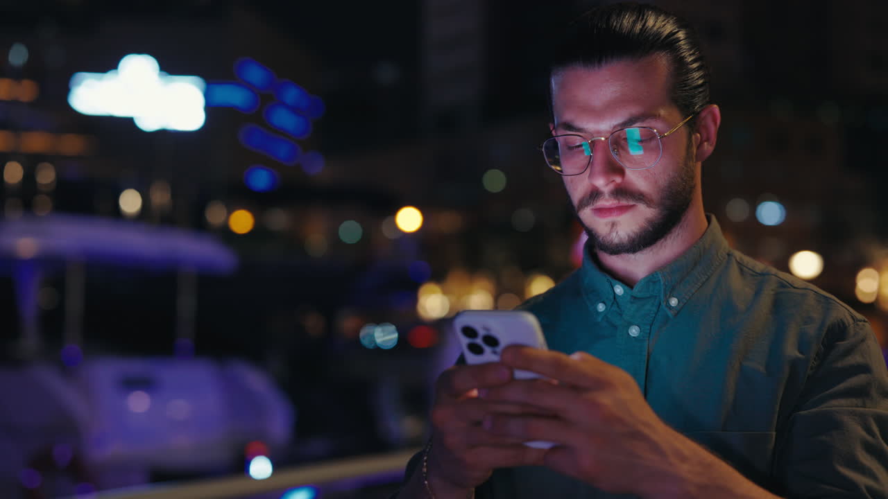 Man using smartphone at night in the city
