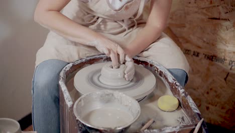 woman shaping clay on a pottery wheel