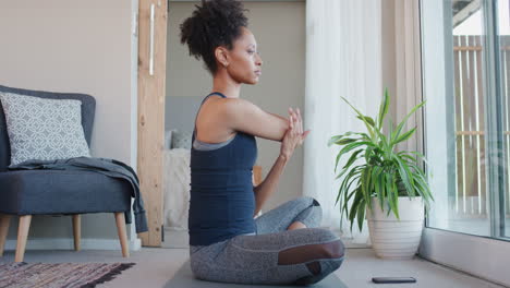 healthy african american woman exercising at home practicing stretching in living room enjoying morning fitness workout