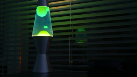 lapso de tiempo de la lámpara de lava verde en una habitación oscura-oficina cerca de una ventana
