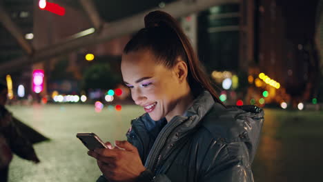 Niña-Feliz-Leyendo-El-Mensaje-Del-Teléfono-En-El-Primer-Plano-De-La-Calle-Nocturna.-Señora-Viendo-Contenido