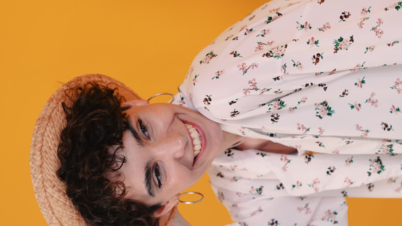mujer sonriente con camisa floral y sombrero de paja