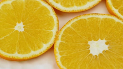 la rotación de una naranja jugosa. 4k video vista superior, rotación de 360 grados, primer plano de una narenja cortada.