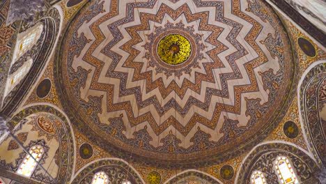 intricately decorated dome and stained glass windows in a grand mosque interior