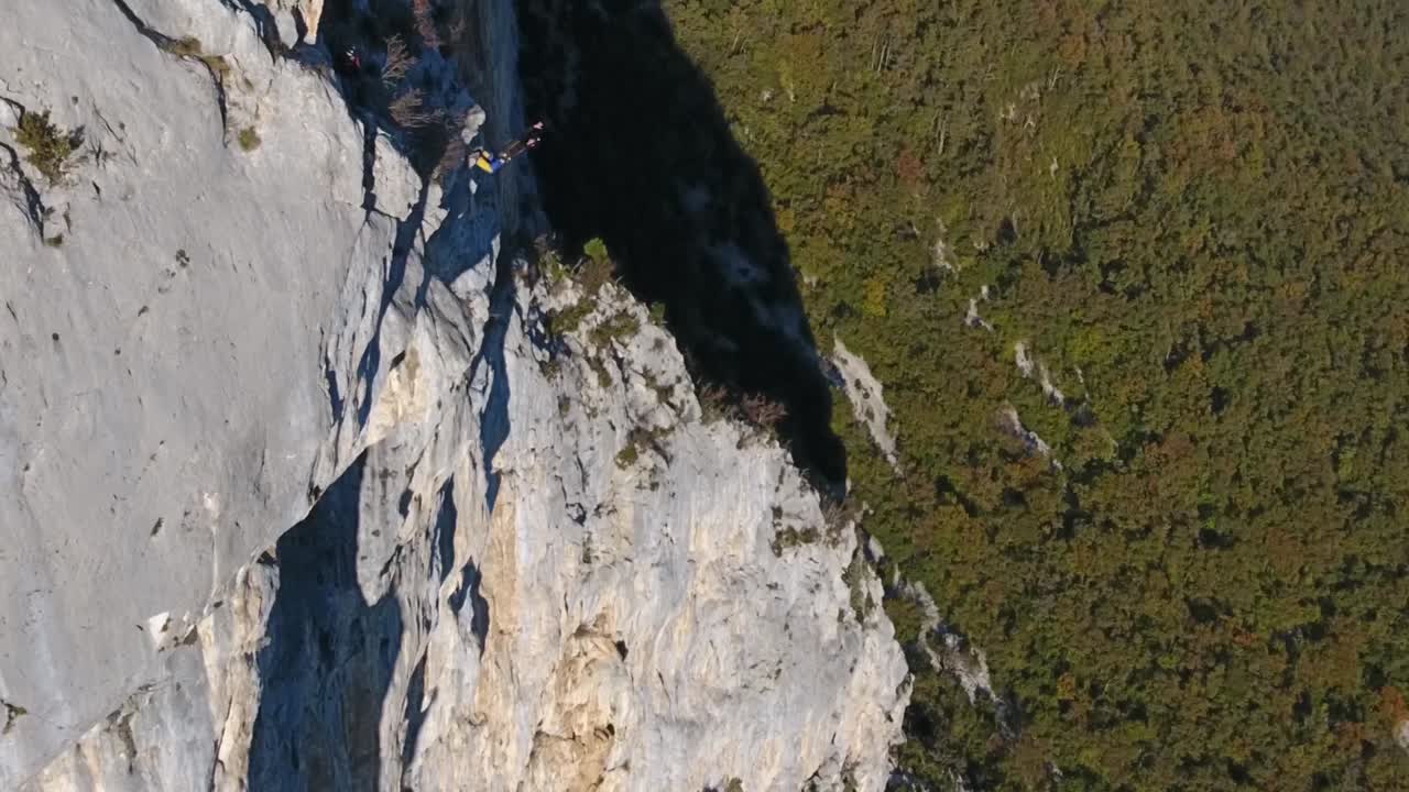 un hombre salta en cámara lenta desde un acantilado en el macizo de choranche vercors, francia.