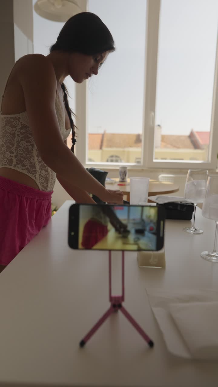 Woman filming a cooking vlog with a smartphone on a tripod