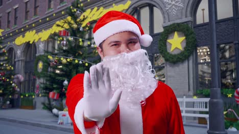 close up de santa claus asiático mostrando señal de mano de parada mientras está de pie en la noche de navidad