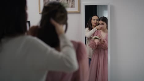 Mirror-reflection-of-caucasian-mother-and-daughter-in-dress-before-prom