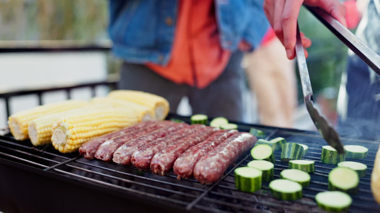 Grilling sausages, corn, and zucchini