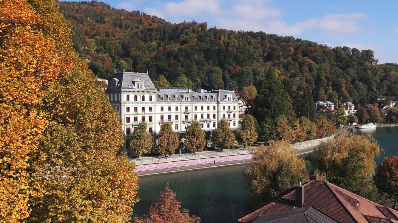 Schloss Oberhofen am Thunersee Segelboot Herbst sonniger Morgen Wolken Luftaufnahme Drohne Thun Schweiz Schweizer Alpen Stadt Berner Oberland Interlaken ruhiges Wasser Vorwärtsschwenk nach oben