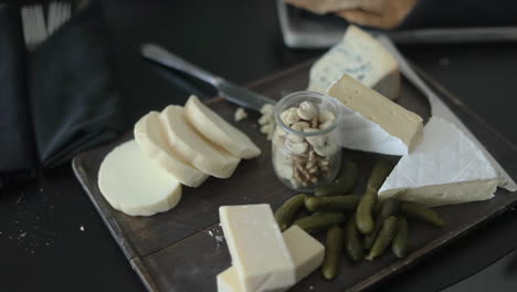 Close-up-to-a-wooden-tray-with-appetizing-cheeses-of-different-types