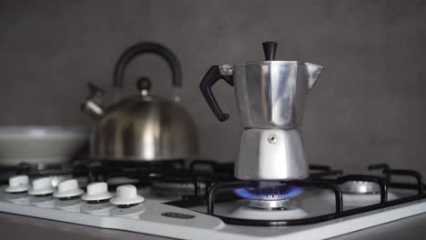 Brewing-coffee-in-moka-pot-on-gas-stove,-turning-on-and-off-by-hand,-long-scene-with-nice-kitchen-background