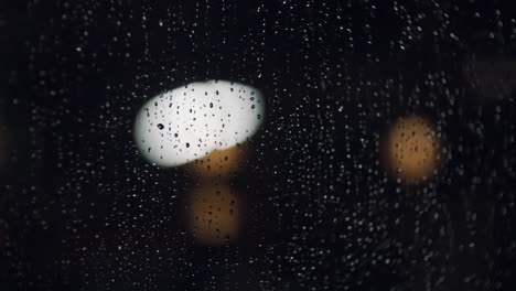 rainy night closeup of raindrops on the window with nice bokeh