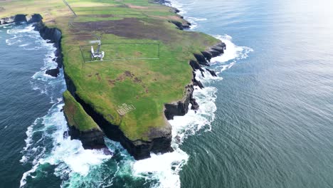 Zerklüftete-Küste-Mit-Wellen,-Die-Gegen-Klippen-Schlagen,-Grüne-Weiden-Am-Meer