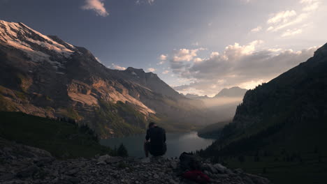 hiker enjoying sunset view from swiss alps