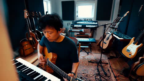 musician playing guitar in a recording studio