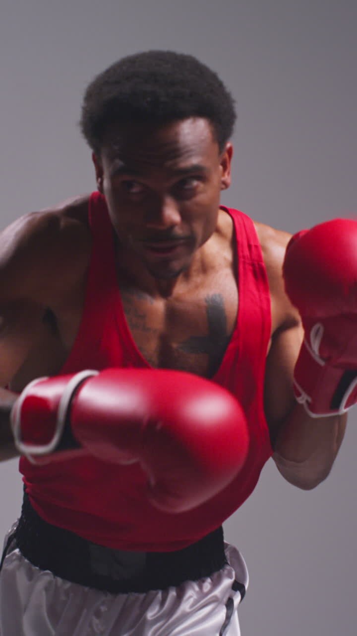 Vertical Video Close Up Shot Of Male Boxer Wearing Gloves In Boxing Match Throwing Punches At Opponent 1