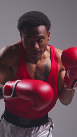 Vertical-Video-Close-Up-Shot-Of-Male-Boxer-Wearing-Gloves-In-Boxing-Match-Throwing-Punches-At-Opponent-1