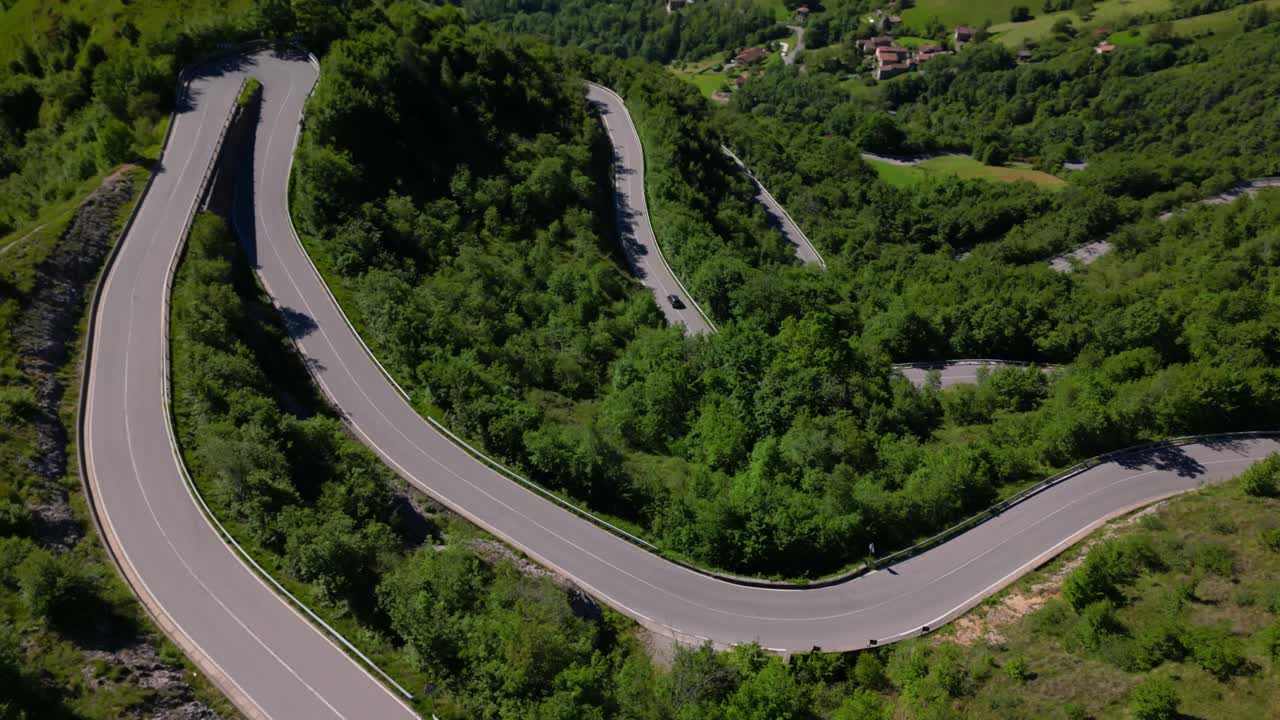 Elevated road snaking between forested hillsides in summer light, capturing rural transportation routes. Shot in Selvino, Italy (Selvino, Italia)