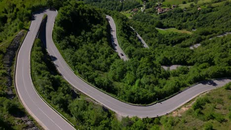 elevated road snaking between forested hillsides in summer light, capturing rural transportation routes. shot in selvino, italy (selvino, italia)