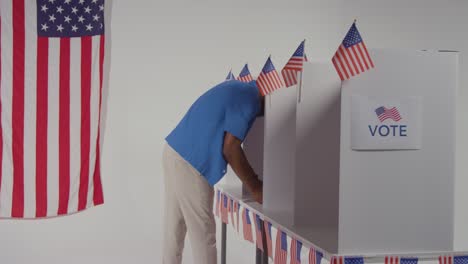 man walking into booth with ballot paper to cast vote in american election 1