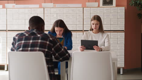 visitors work on computers in library hall. students connect to internet network learning online sources in university reading room. education technology