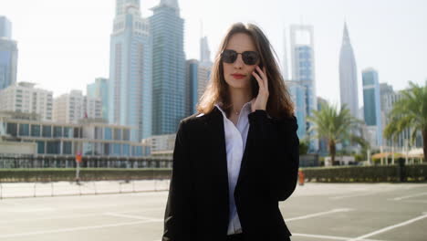 Elegant-businesswoman-with-phone-outdoors