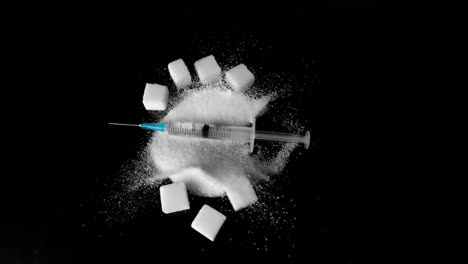 syringe of insulin falling into pile of sugar next to sugar cubes