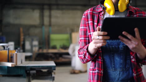 woman carpenter using tablet in a workshop