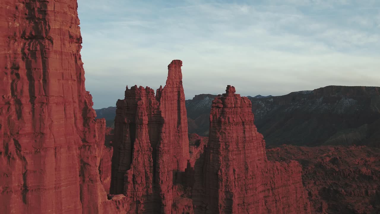 A long drone shot of flying through the grand Fisher Towers in Utah