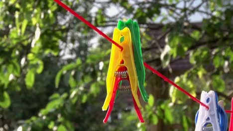 multicoloured plastic clothes pegs on a washing line