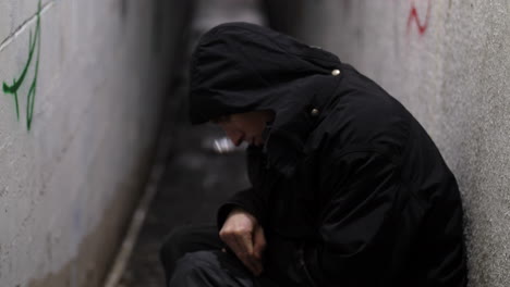 street person experiencing withdrawal in alley outside coming into focus