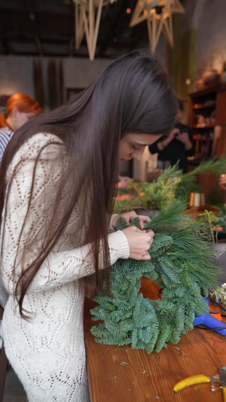 mujer haciendo una corona de Navidad