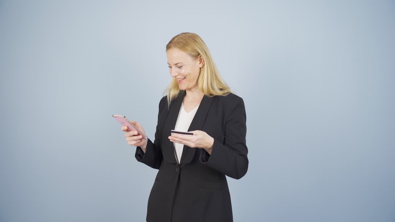 Donna d'affari che fa acquisti con il telefono e una carta di credito
