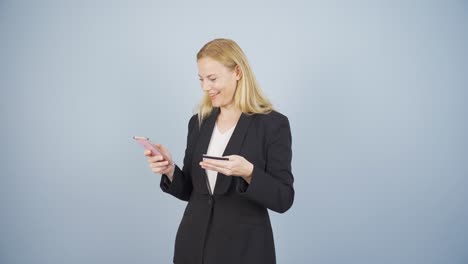 business woman shopping on the phone with a credit card.