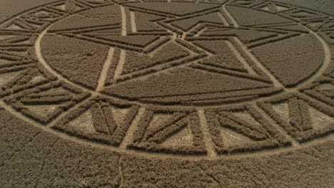 west meon countryside barley field elaborate crop circle aerial view rising pull back