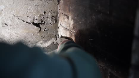 primer plano de una mano aplicando cemento en una pared de ladrillo, centrarse en la textura y el trabajo manual
