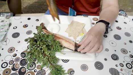 niña lista para comer pescado ahumado de manera tradicional noruega y quitar la piel de pescado en el bosque de noruega