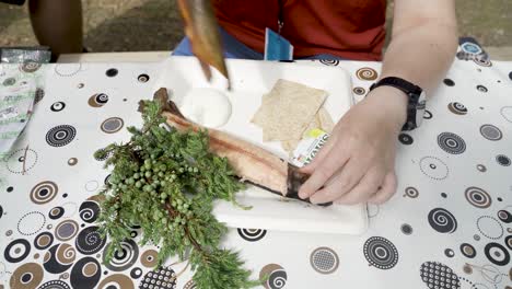 girl ready to eat smoked fish in traditional norwegian way and remove the fish skin in the forest of norway