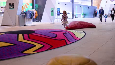 a child joyfully runs inside the museum