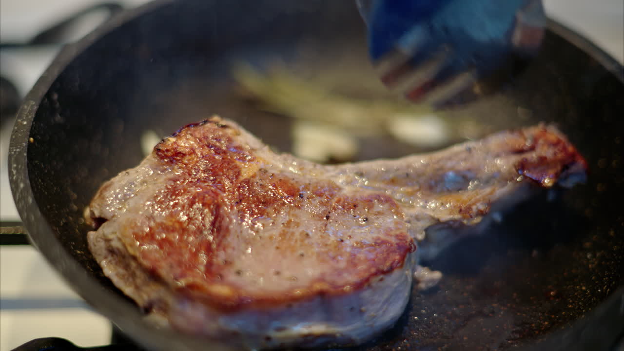 Juicy ribeye steak meat beef being prepared with rosemary and garlic