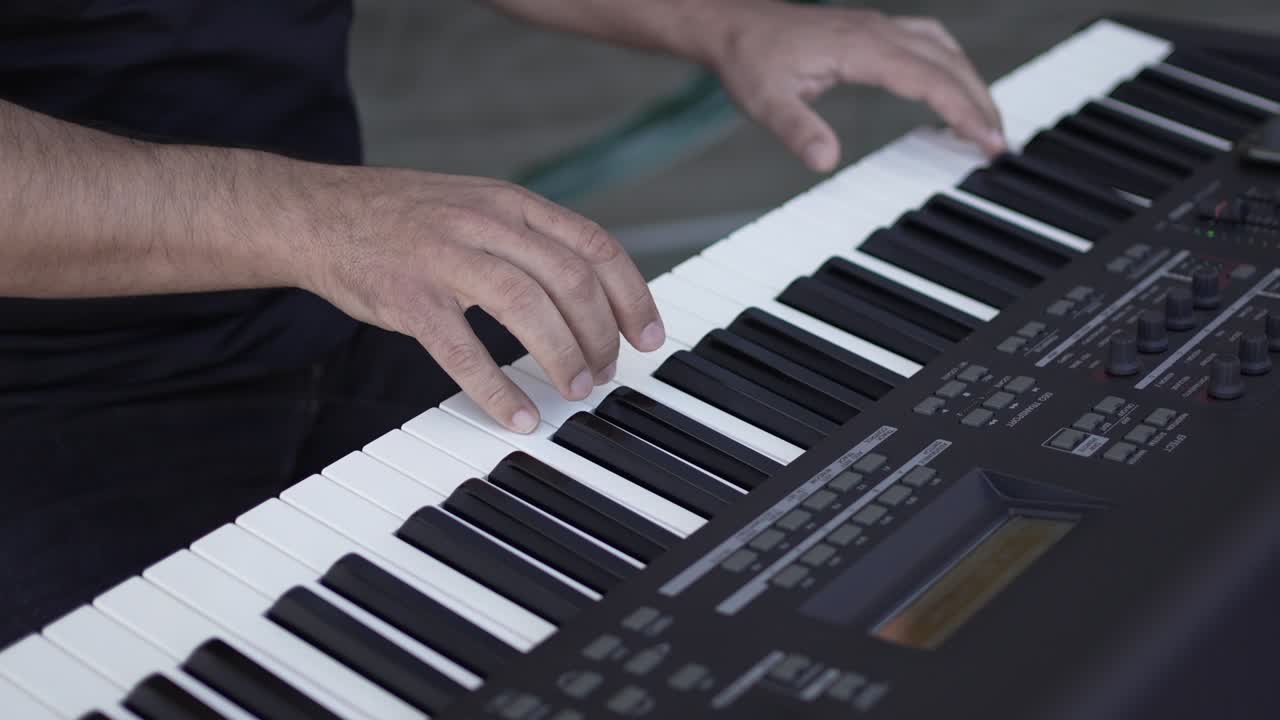 Hands performing on a digital keyboard, focusing on the keys and player’s technique