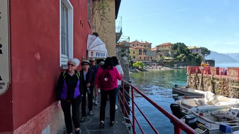 people walking by lake como in varenna