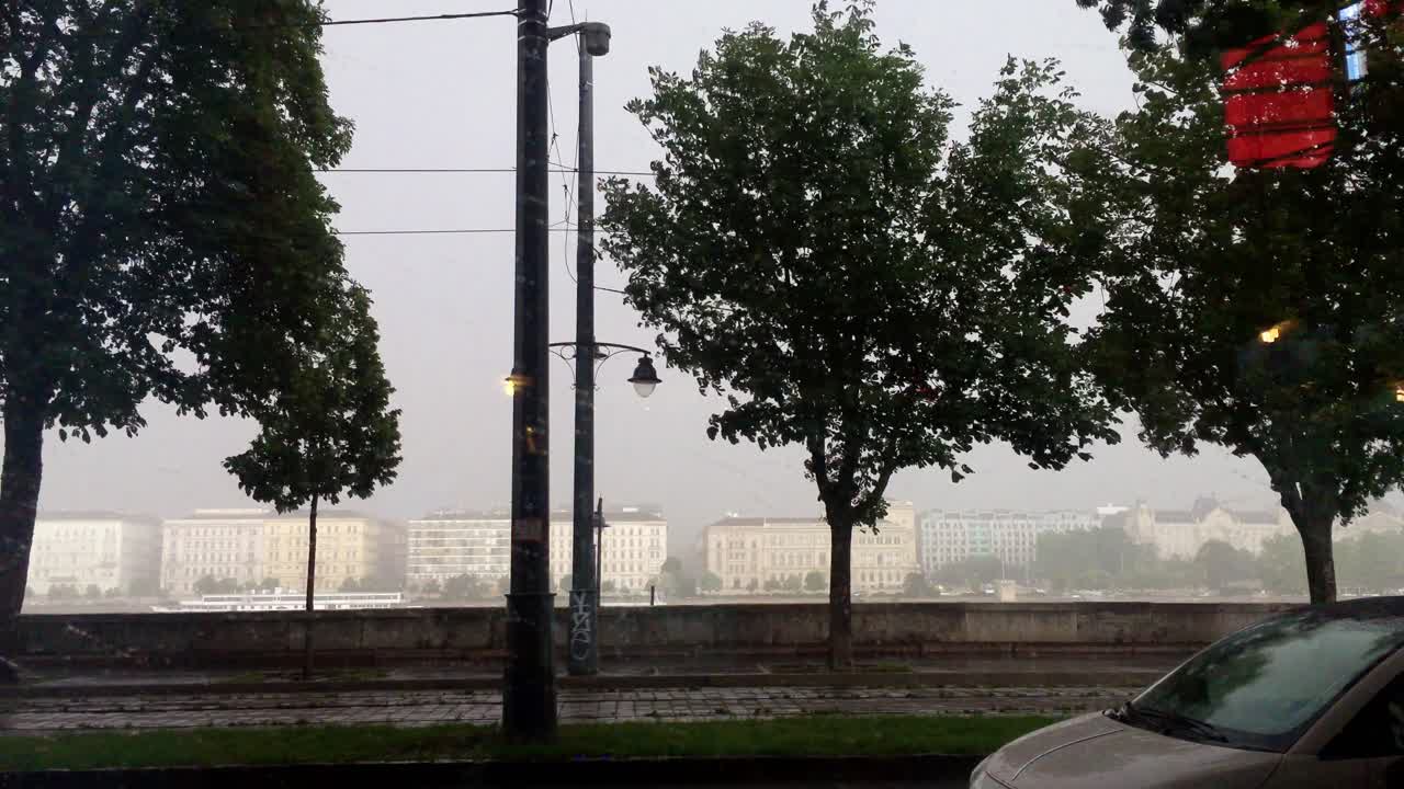 Stormy weather in the city of Budapest, Hungary. Biker riding in the rain. Stormy weather in Budapest. Trees waving in storm.