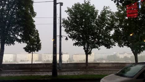 stormy weather in the city of budapest, hungary. biker riding in the rain. stormy weather in budapest. trees waving in storm.