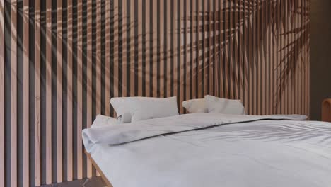 Ein-Modernes-Hotelzimmer-Mit-Minimalistischem-Interieur-In-Strandnähe-Mit-Palmenschatten-Auf-Den-Möbeln